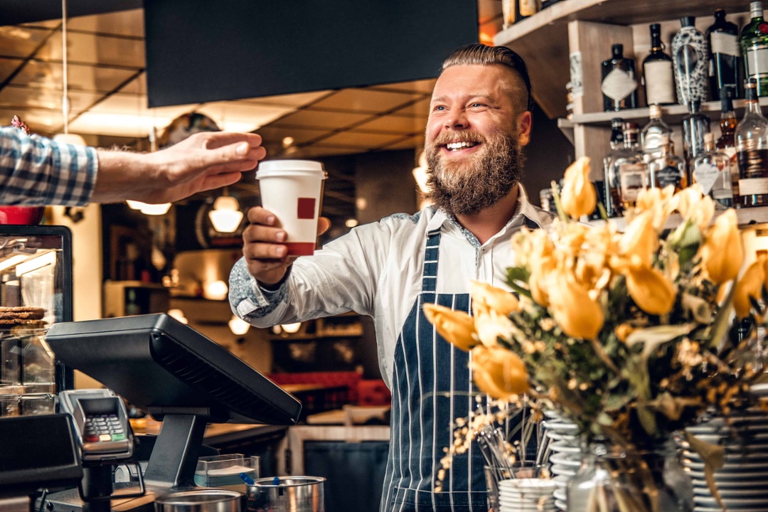 Cashier giving a cup of coffee