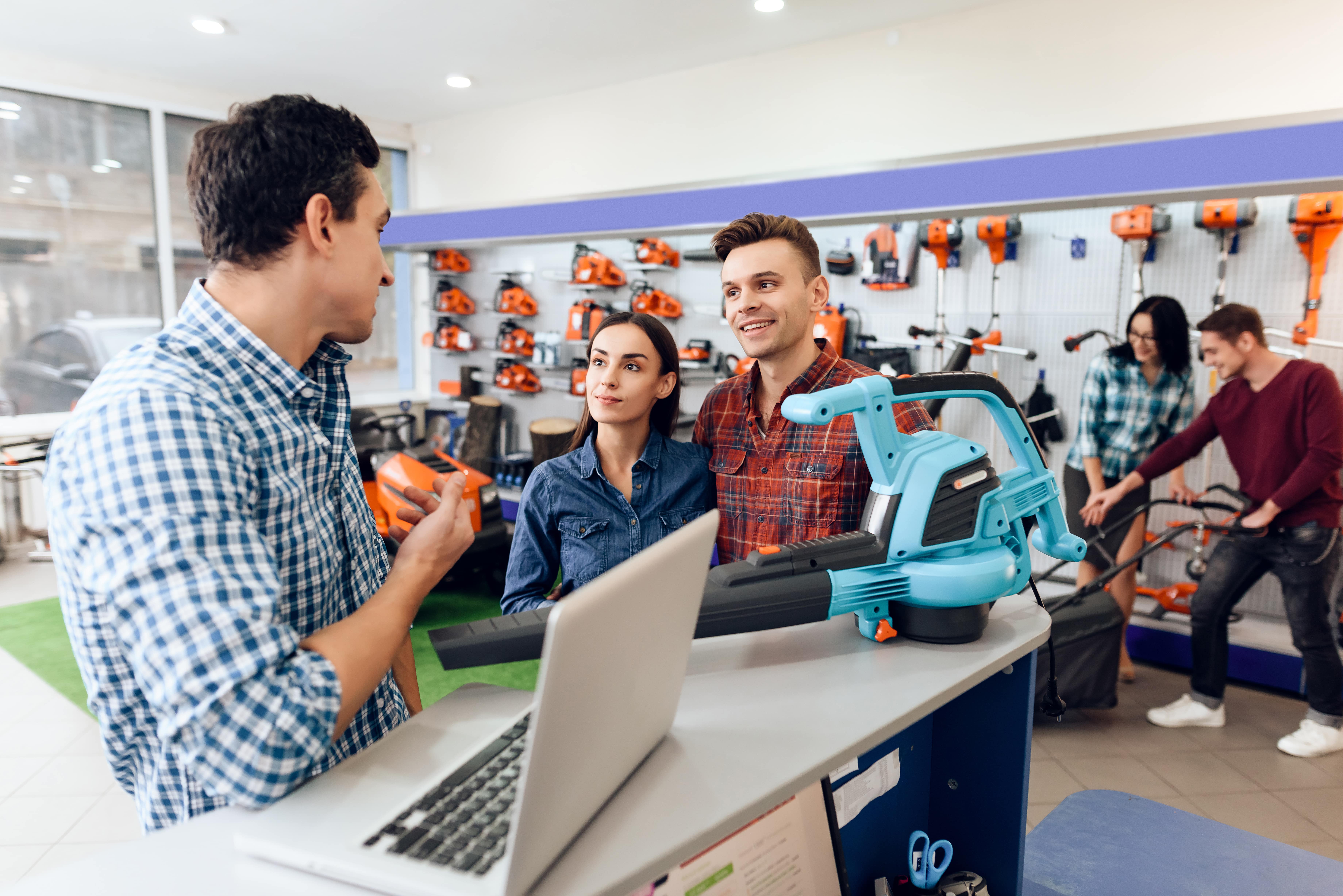 Happy customers speaking with hardware store employee