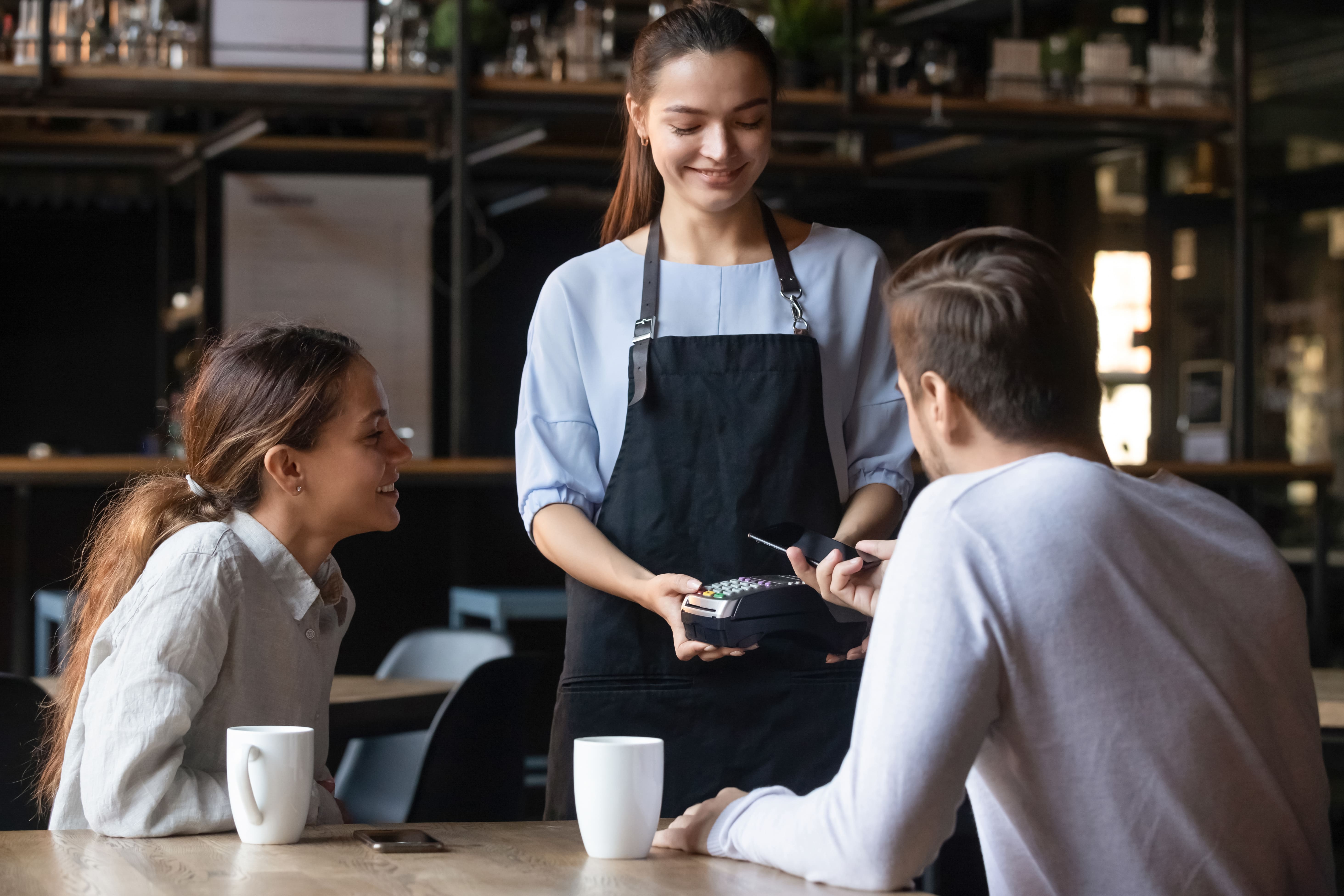 Client in cafe paying using mobile application payment